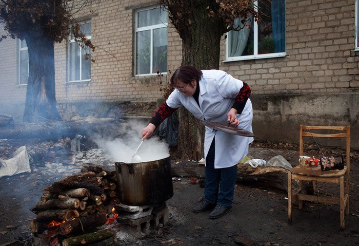 Медсестра готовит пищу на огне из-за нехватки газа в больнице, Донецк, 17 декабря 2014. Фото: EPA / UPG